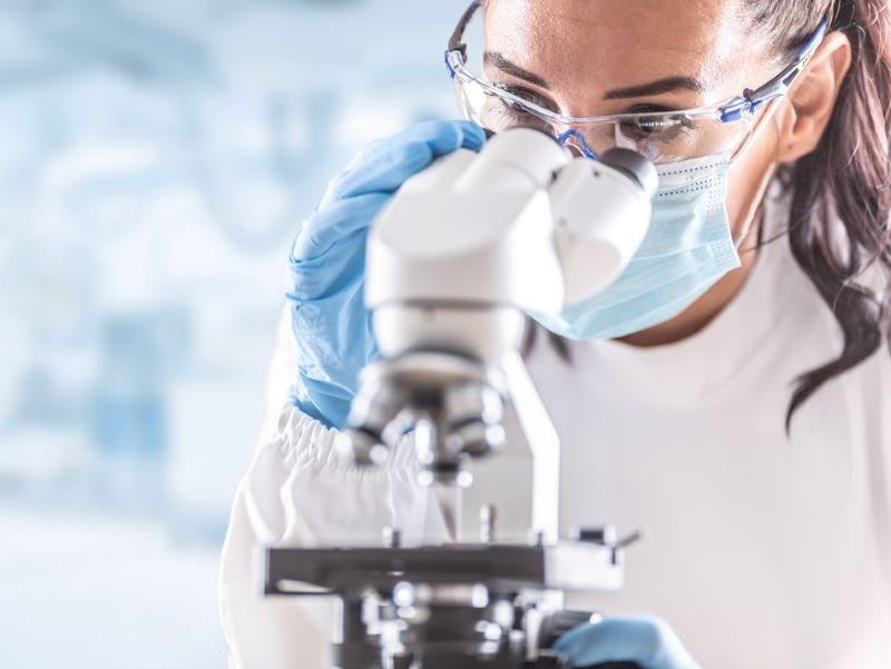 Image of a woman researcher looking through a microscope